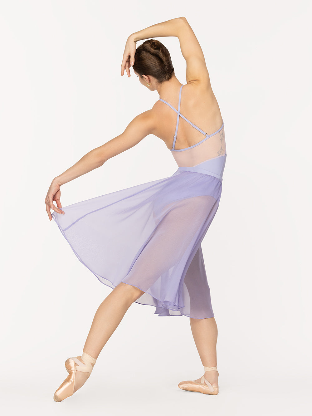 Eleve Dancewear Ebony Leotard in Flower Toss print, back view of dancer on tendu derriere croise