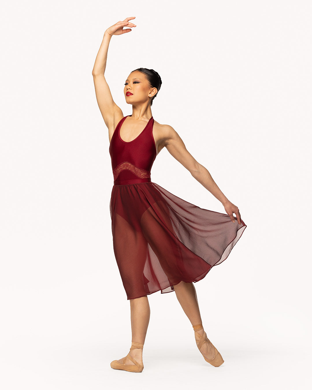 Eleve Dancewear Miyesha Leotard in Garnet print color, front view of dancer on tendu derriere efface