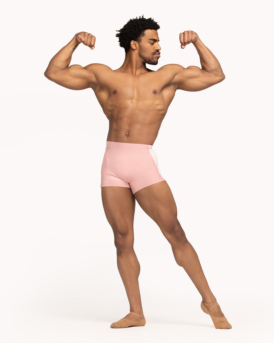 Eleve Dancewear Juan Shorts in Rose color, front view of dancer posing and flexing