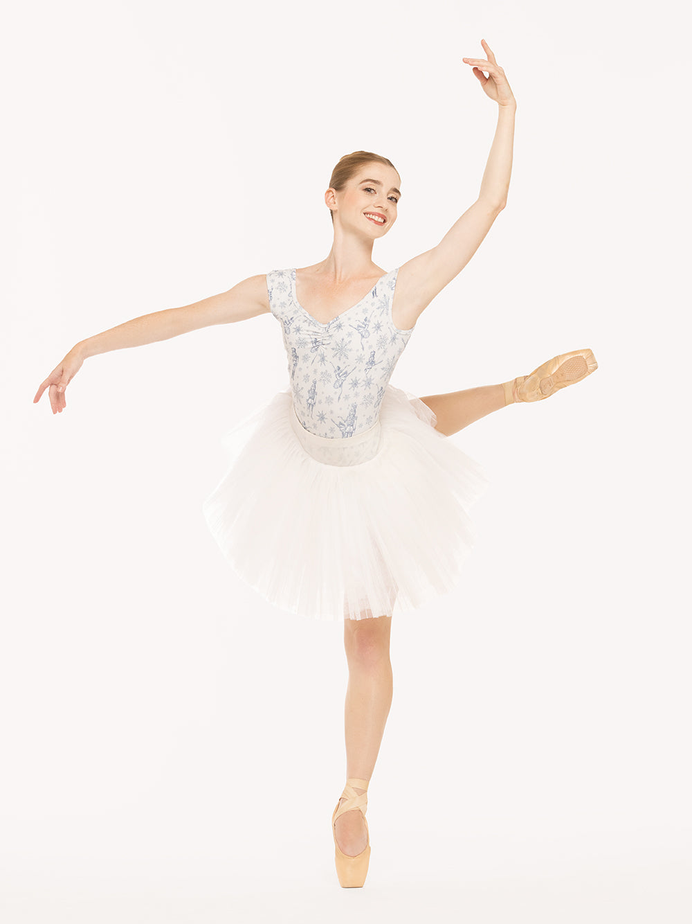 Eleve Dancewear Heather Leotard in Snow Scene print, front view of dancer on pique attitude derriere croise