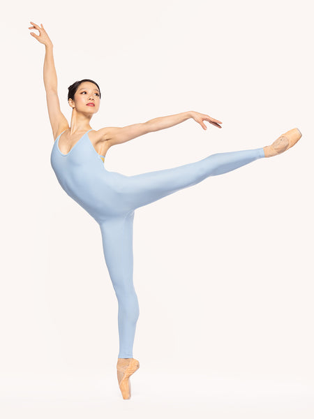 Eleve Dancewear Iris Unitard in True Blue color, front view of dancer on first pique arabesque