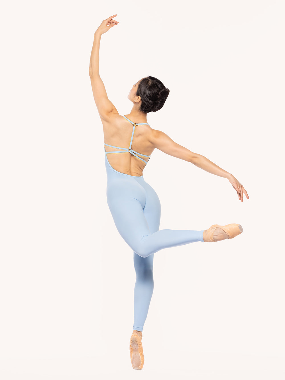 Eleve Dancewear Iris Unitard in True Blue color, back view of dancer on pique attitude derriere