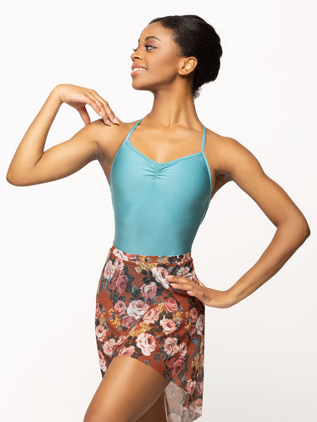 Model is wearing shiny Caribbean blue leotard with pinch detail with a copper floral print high-low mesh skirt