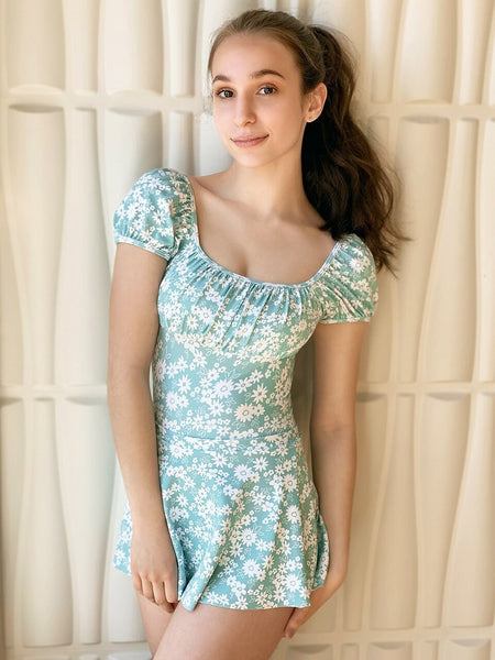 Model wearing a blue floral leotard with matching skirt 