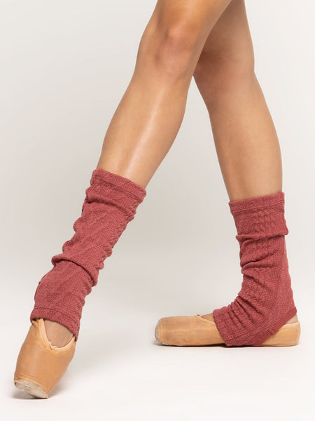 Front of stirrup ankle length leg warmers in dark pink cable knit