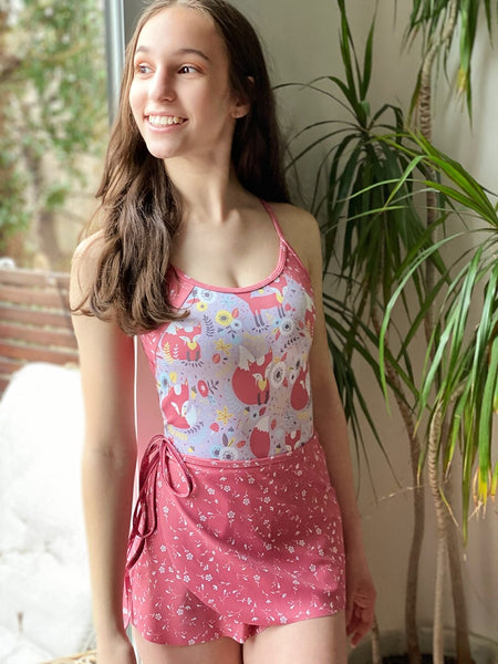 Model wearing a fox print leotard with a matching pink floral wrap skirt