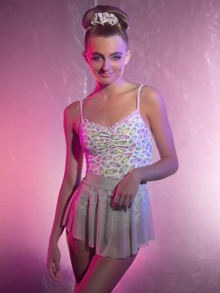 Model in candy print leotard, hair band and translucent mesh skirt. 
