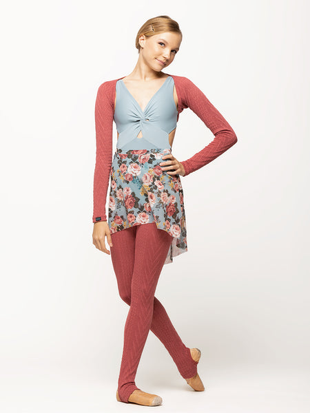Model is wearing a dark pink cable knit shrug with a light blue twist detail leotard, a light blue floral print mesh skirt, and matching dark pink cable knit leg warmers