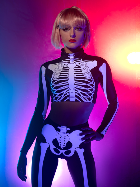 Model in Crop-top skeleton x-ray and matching tights staring plainly at camera 
